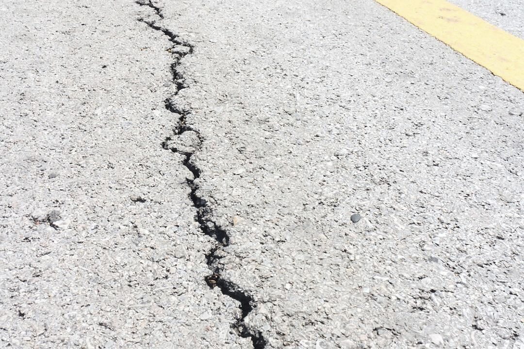 A crack running across a pale concrete surface.